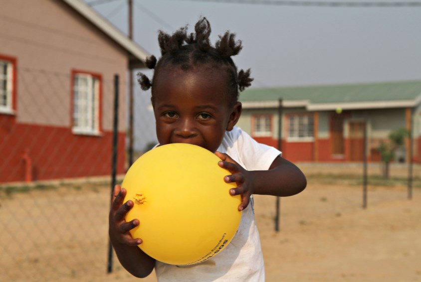 Jente fra barnebyen i Huambo, Angola, leker med en ballong. Foto: Bjørn-Owe Holmberg
