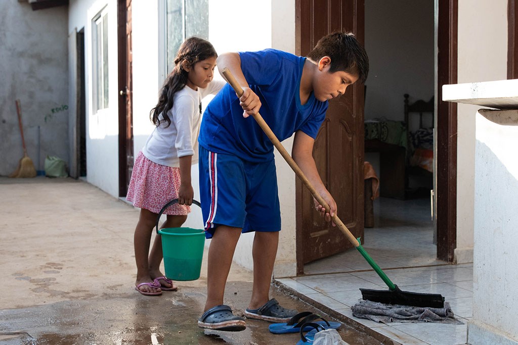 Kl 15.00 Alle i huset har forskjellige oppgaver som de har ansvar for. I dag vasker Marco gulv og niese Kathy hjelper til. – Jeg er stolt av Marco, han klarer seg bra på skolen og han hjelper mye til i huset, sier storesøster Roxana.