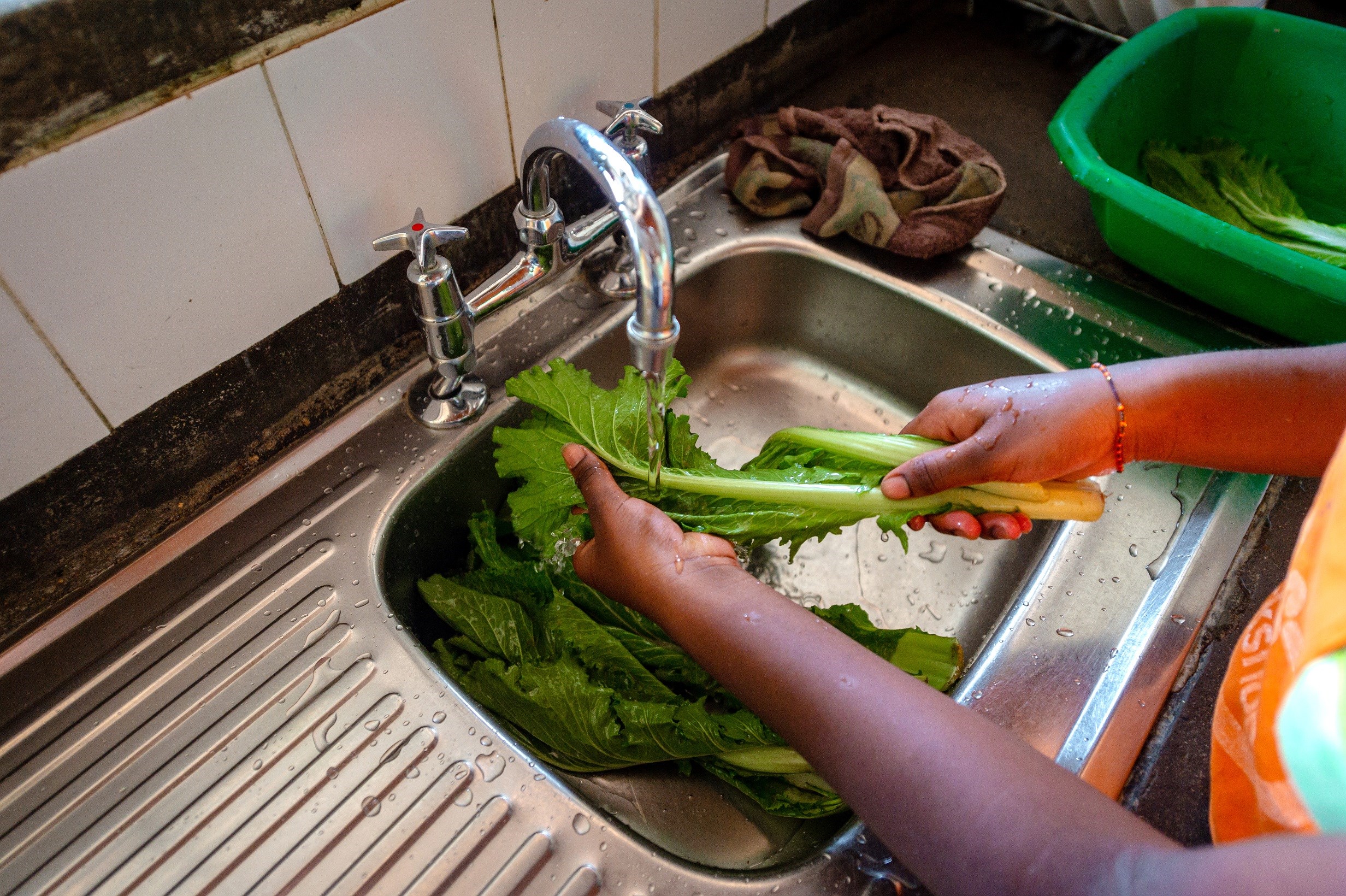 Kl 12.30 Alle barna har faste dager hvor de hjelper til med å lage mat. Nani vasker spinatblader og broren kutter dem i biter. I dag er det kylling, ris og grønnsaker på menyen.