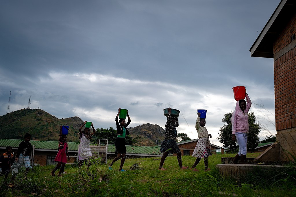  Kl 18.00 Den siste oppgaven for dagen er å pumpe vann fra landsbybrønnen. Nani pumper mens de andre jentene fyller bøttene sine. Hun skal tidlig til sengs i dag for å være klar til en ny skoleuke med
læring og moro.