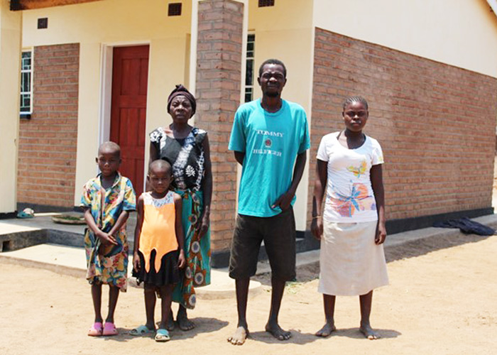 Gladys and her 4 children standing outside their new house. Photo: SOS Children's Villages Malawi