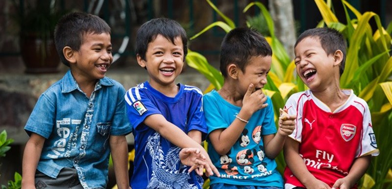 Fire gutter fra en SOS-barneby i Kabodsja som smiler og ler. Foto: Rasmus Preston