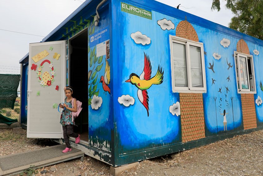 En container er malt i blått og pyntet med blomster. Dette er trygghetssonen i en flyktningleir, der barn kan leke og lære. Foto: Giorgos Moutafis
