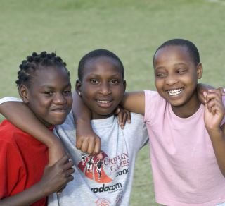 Tre søsken i en barneby i Tanzania. Foto Christian Lesske