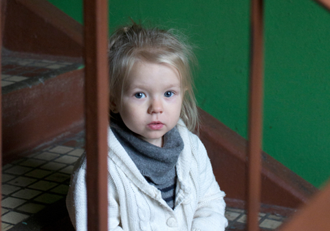 Bilde av ei jente i hvit genser, som sitter på trappene. Foto: Nina Ruud