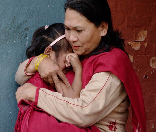 Jente fra en SOS-barnebyers program i Nepal får trøst av SOS-mamma. Foto: Nina Ruud