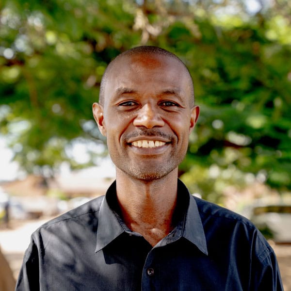 Mulenga Chibwe, sosialarbeider SOS-barnebyer Zambia. Han er glattbarbert på hodet og har svart t-skjorte. Foto Maisie Marshall