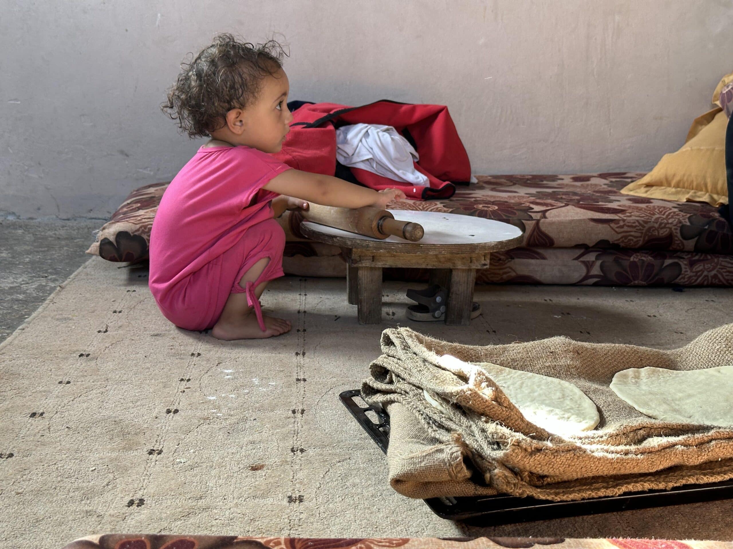 Liten jente som sitter alene i et rom på gulvet i Gaza