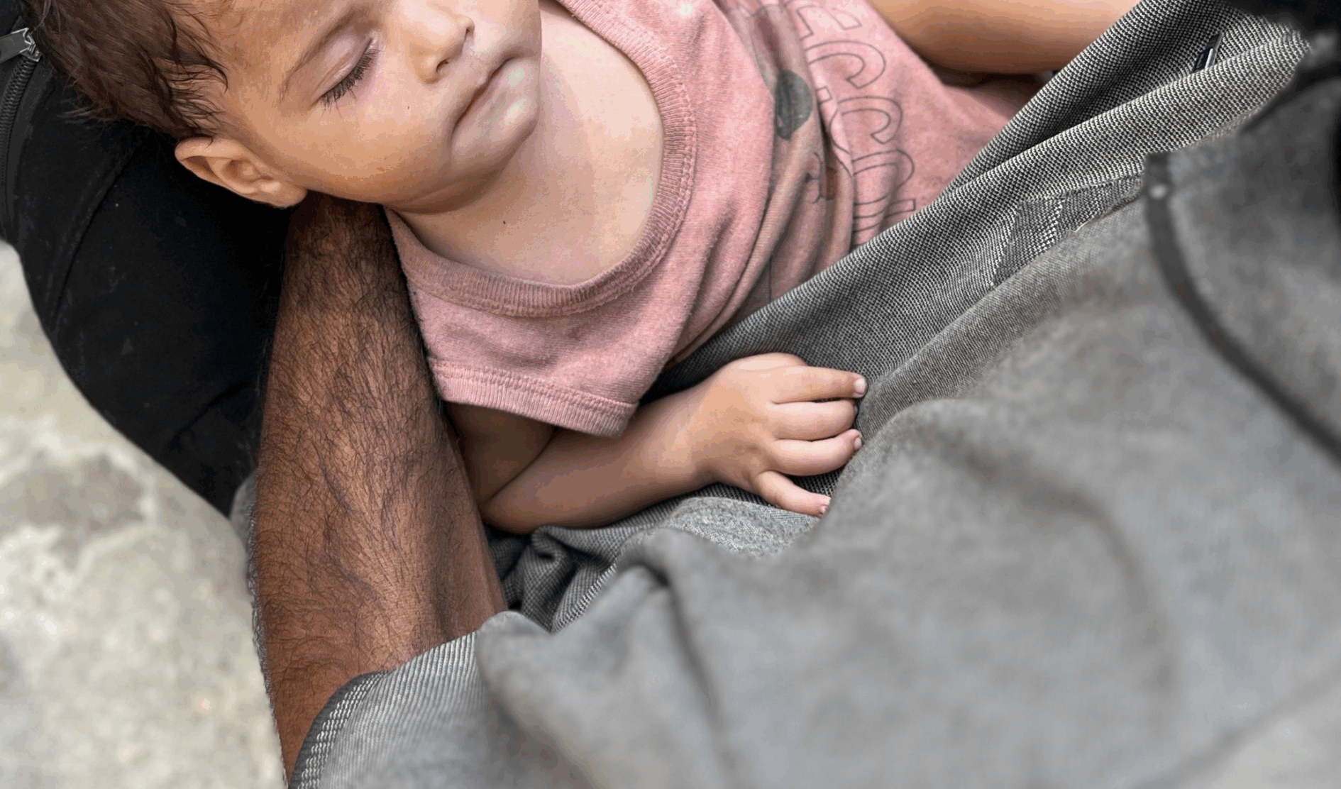 En baby I Gaza sover i armene til en mann.