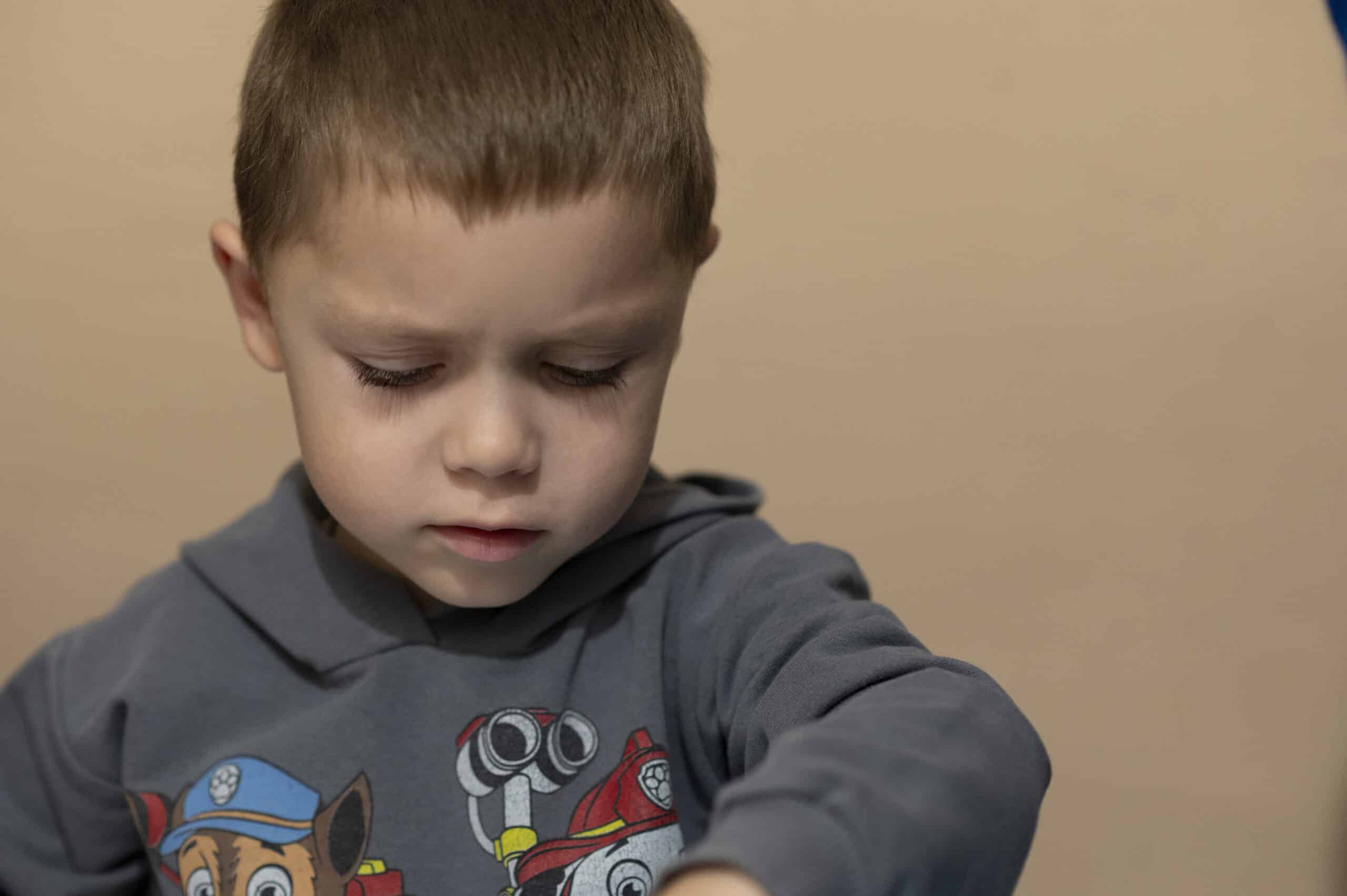 Vanya (5) sitter konsentrert og leker i et trygt rom i Tsjernihiv i Ukraina.