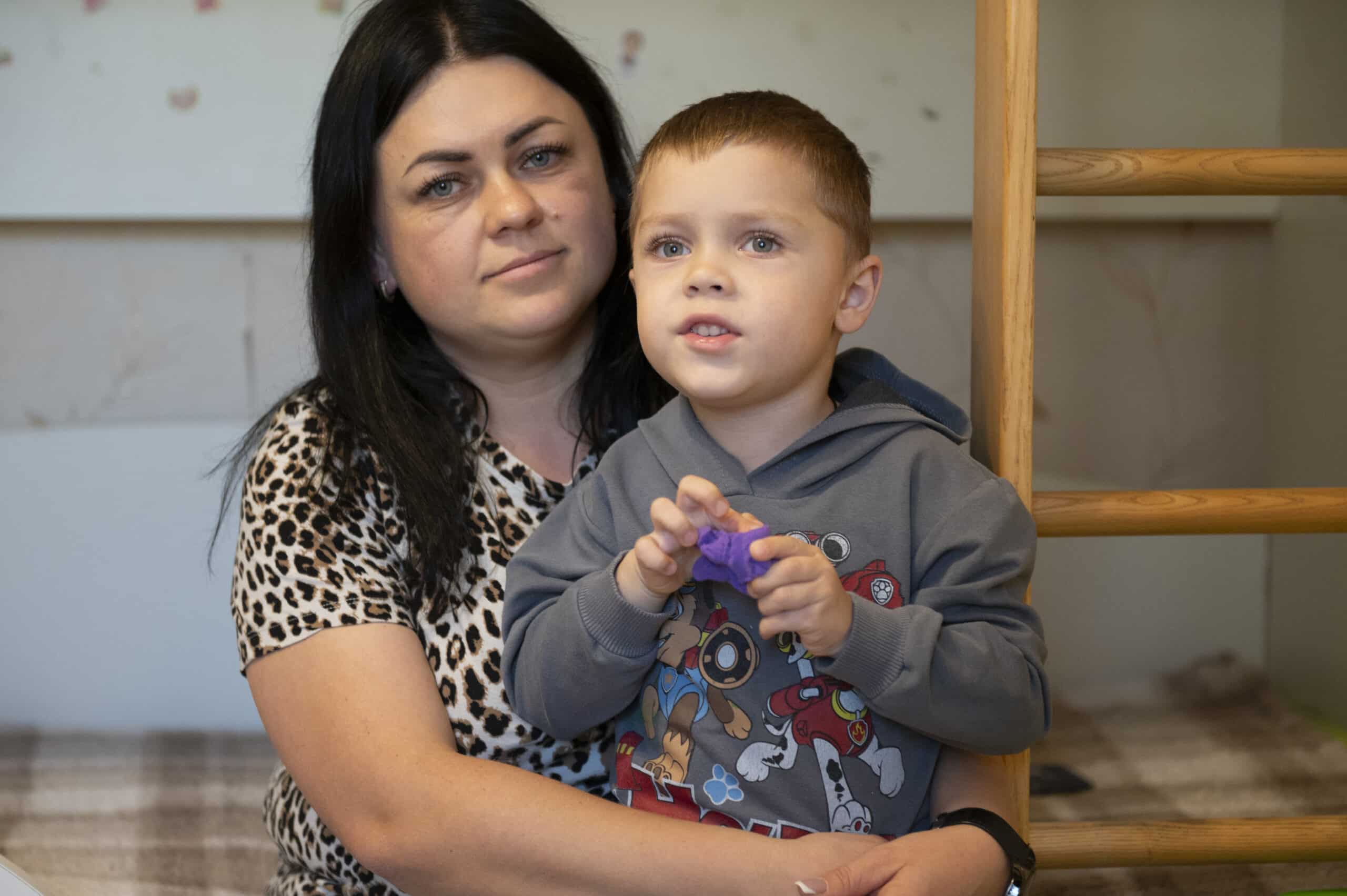 Vanya (5) sitter på fanget til moren sin, Ganna, i et trygt rom i Tsjernihiv i Ukraina.