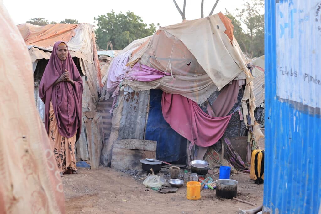 Det er sultkatastrofe i Somalia. Mange familier må flykte. En kvinne står foran en provisorisk bolig. Foto: SOS-barnebyer Somalia
