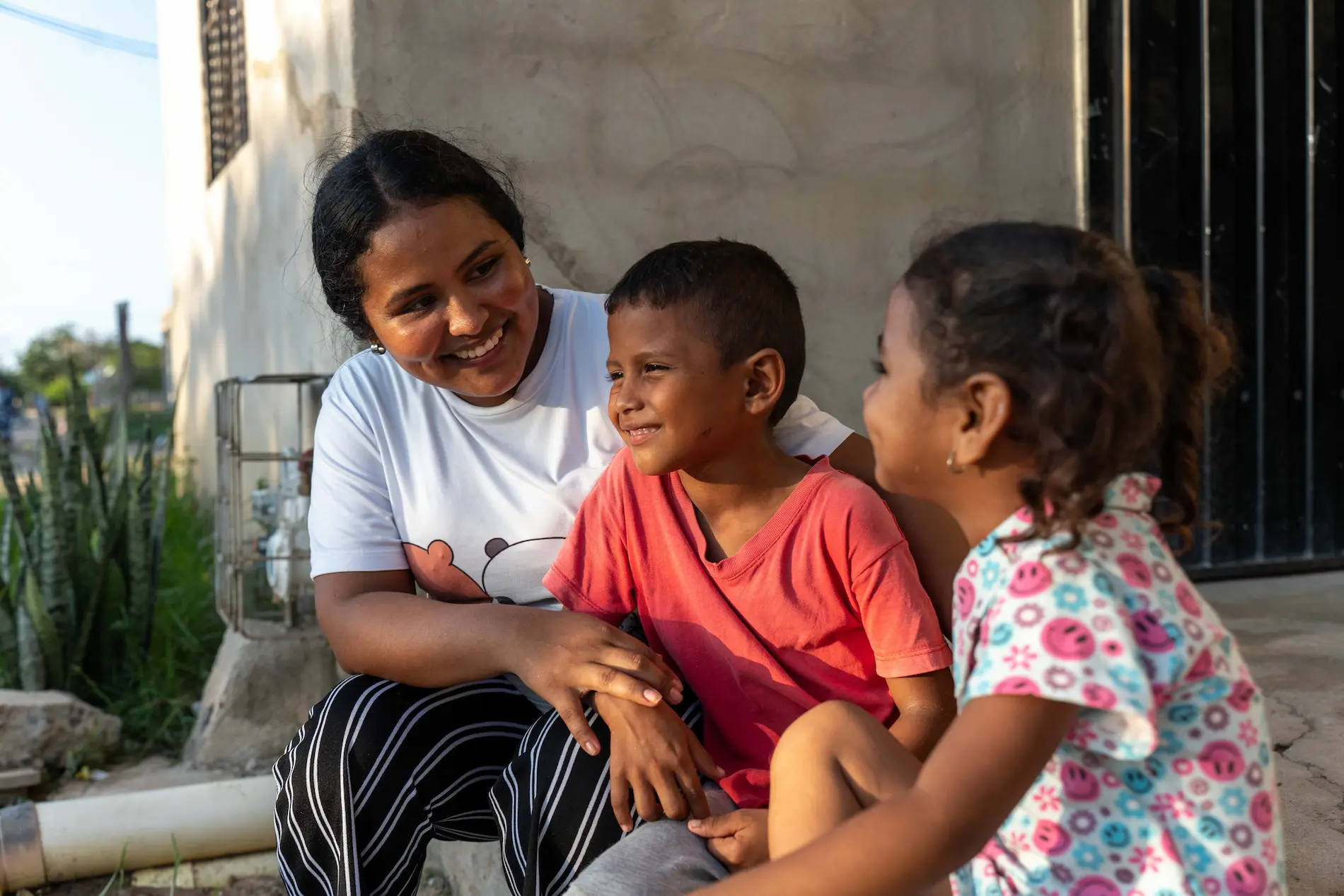 Franchelis Pana Epiayu sitter sammen med to av barna sine utenfor hjemmet sitt i La Guajira-regionen i Colombia.