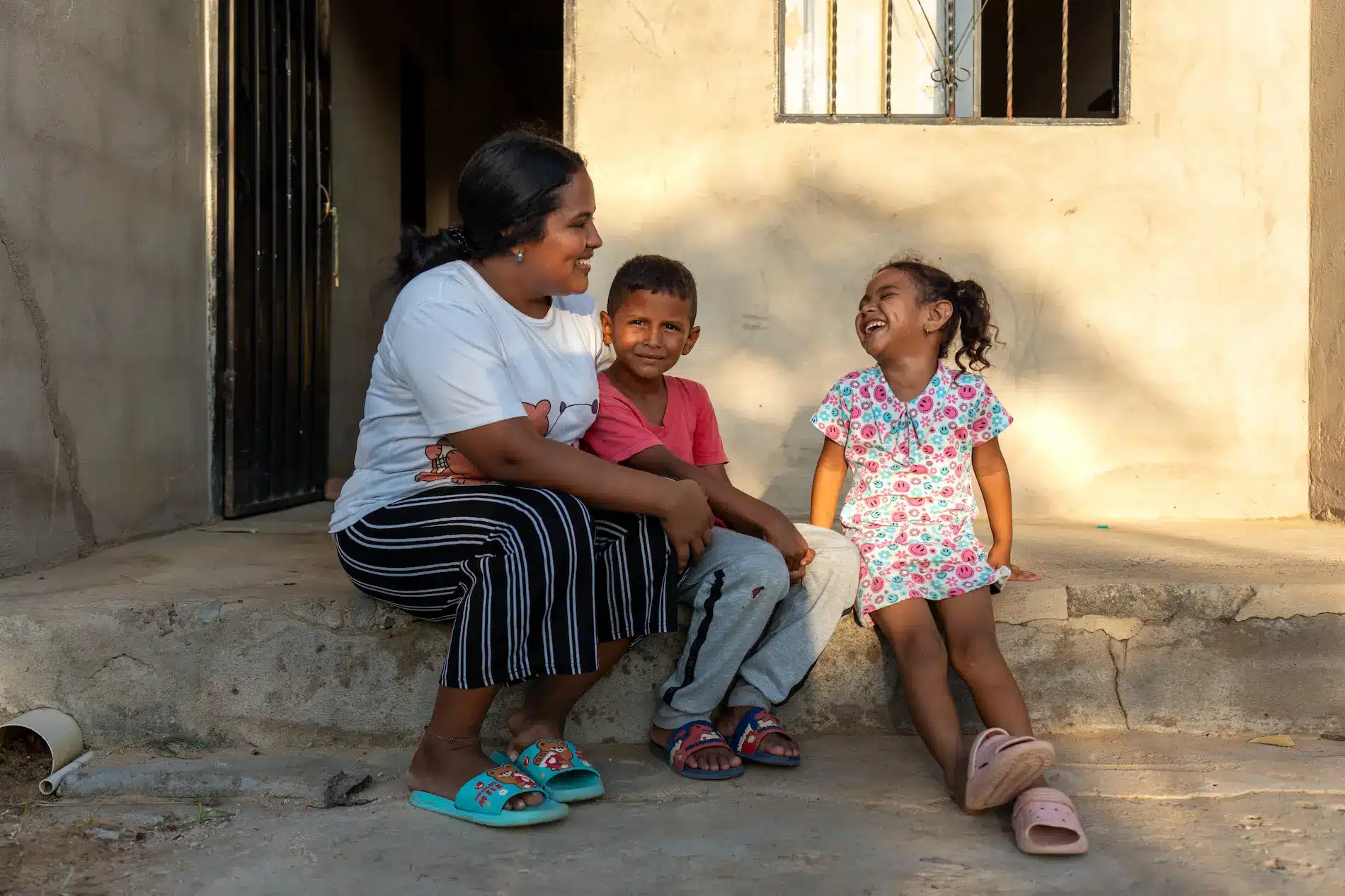 Franchelis Pana Epiayu sitter sammen med to av barna sine utenfor hjemmet sitt i La Guajira-regionen i Colombia.