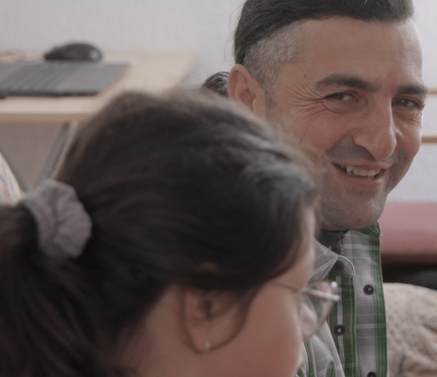 Dragan Arsić smiler til en av døtrene sine hjemme i familiens stue i Gračanica, Kosovo.
