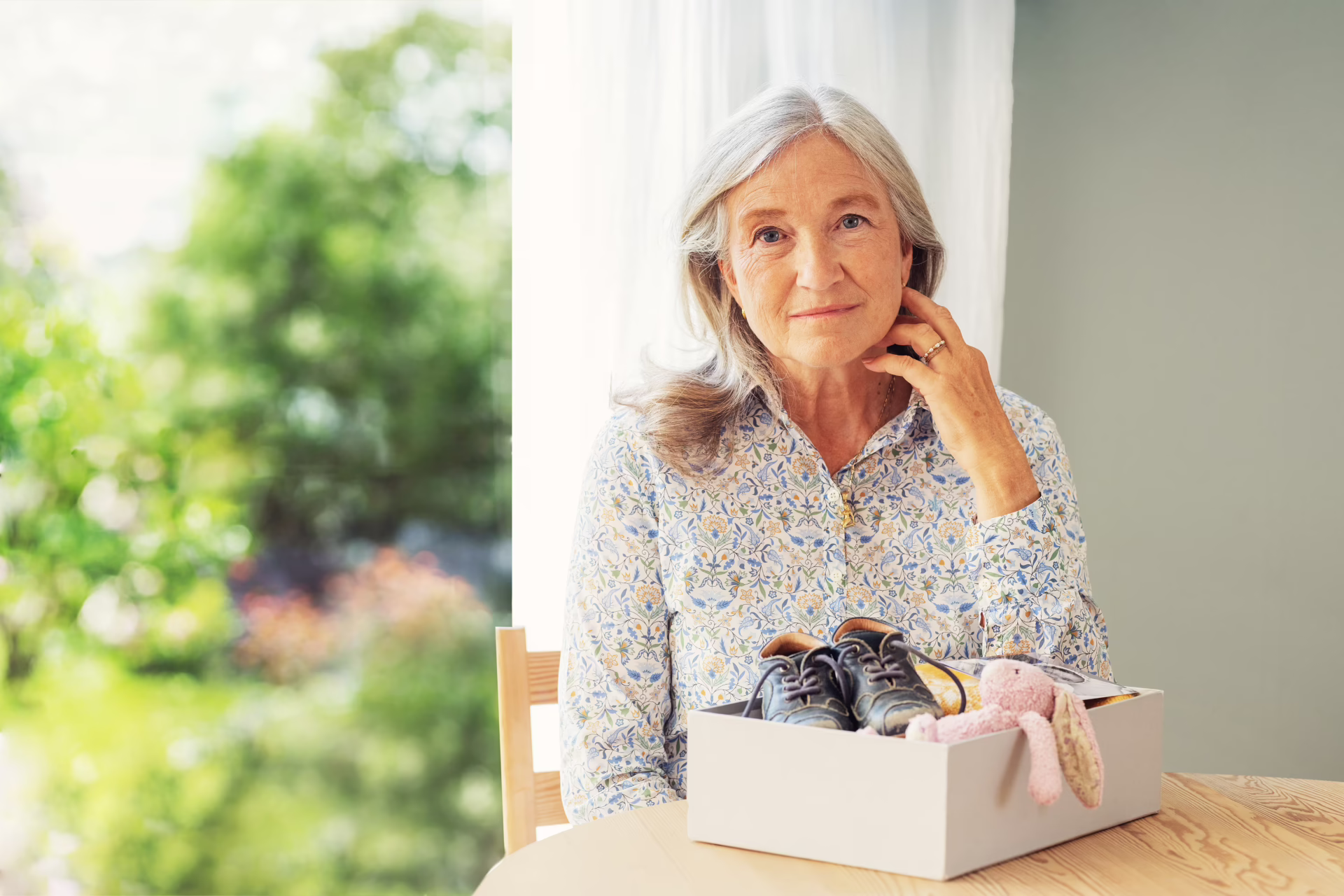 Eldre kvinne med en eske med gamle familiegjenstander og minner