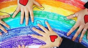 Hender som har et malt, rødt hjerte på håndflaten, holder på en tegning av regnbuen. Illustrasjosnfoto: SOS-barnebyer Italia
