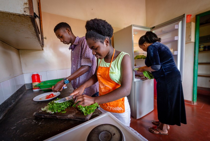 Barna hjelper til med matlaging. Foto:Corner van Heerden