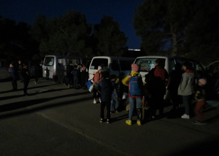 Barn fra SOS-barnebyers program står utenfor bilene de har brukt til evakueringen. 