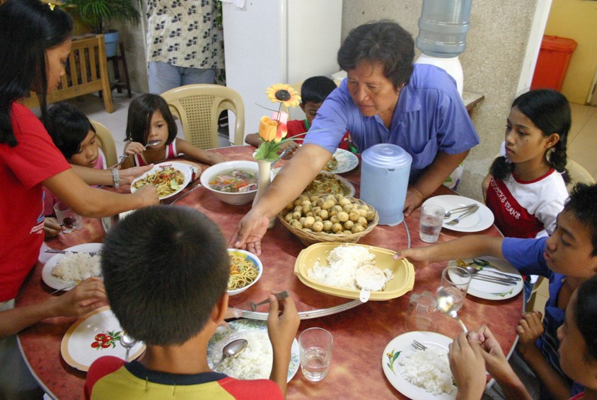 Familie samlet rundt måltid i SOS-barnebyen, Cebu, Filippinene. Foto: SOS-arkiv