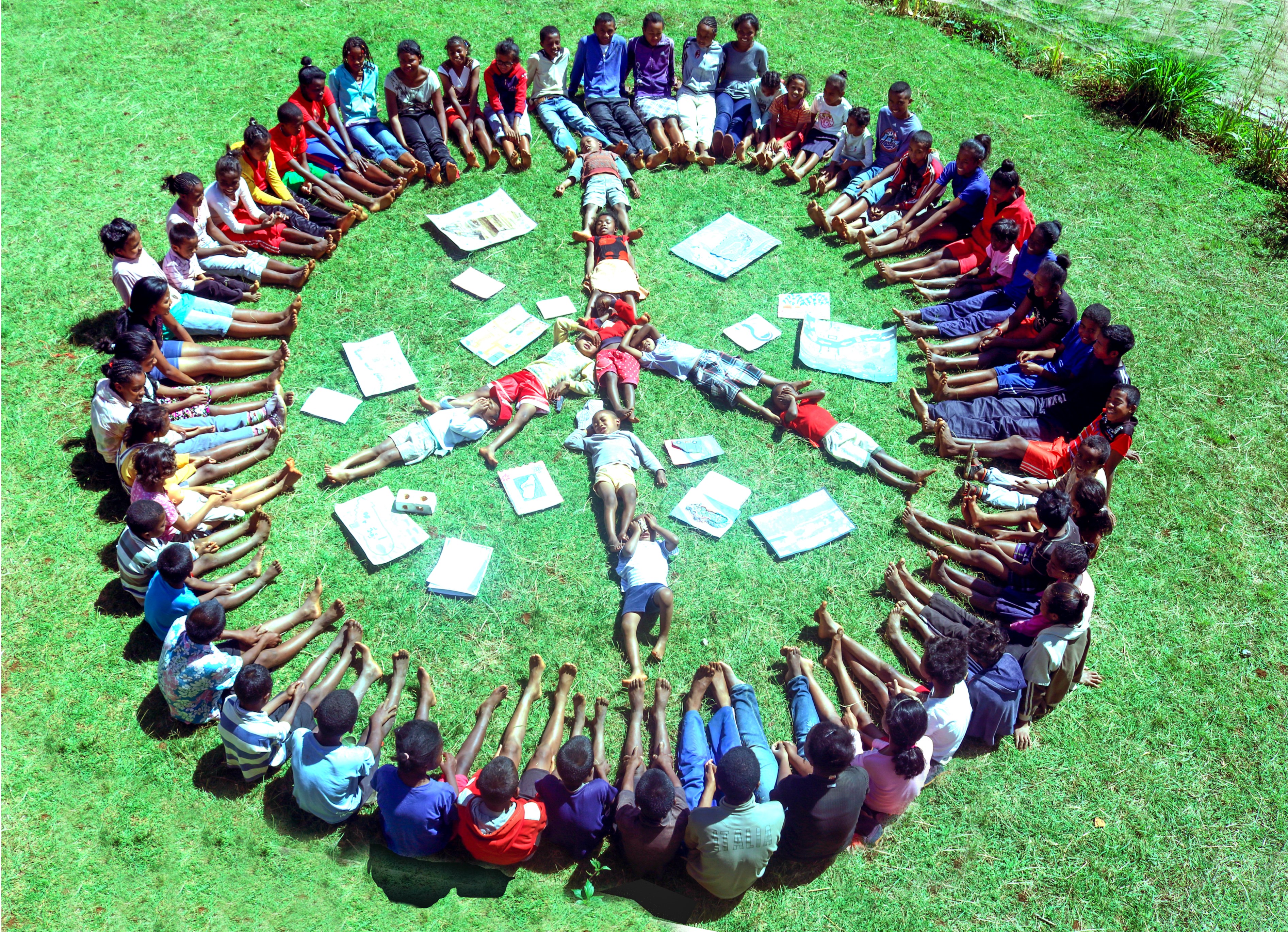 Barn sitter med føttene ut og danner Peace tegnet. Undervisningsfilmer for ungdom