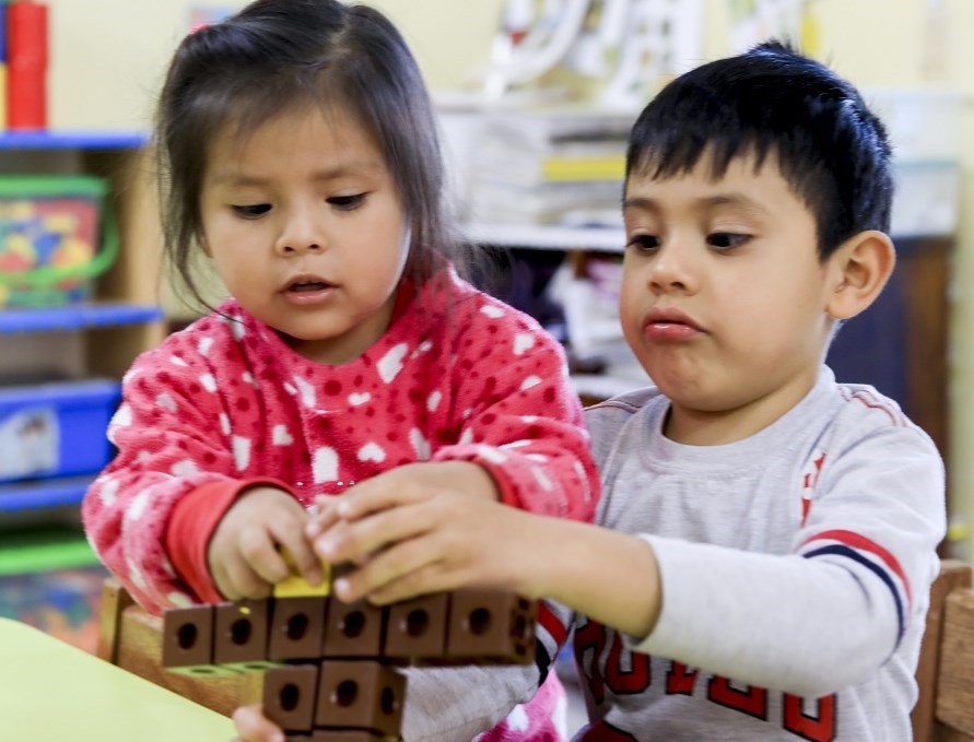 Førskolebarna samarbeider om å bygge med klosser.