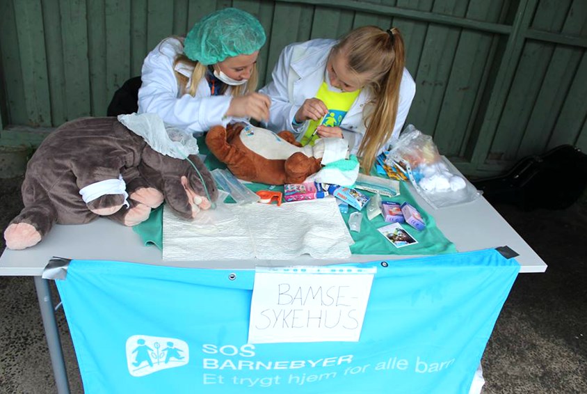 To unge jenter i hvite frakker er leger på bamsesykehus i Ørje.