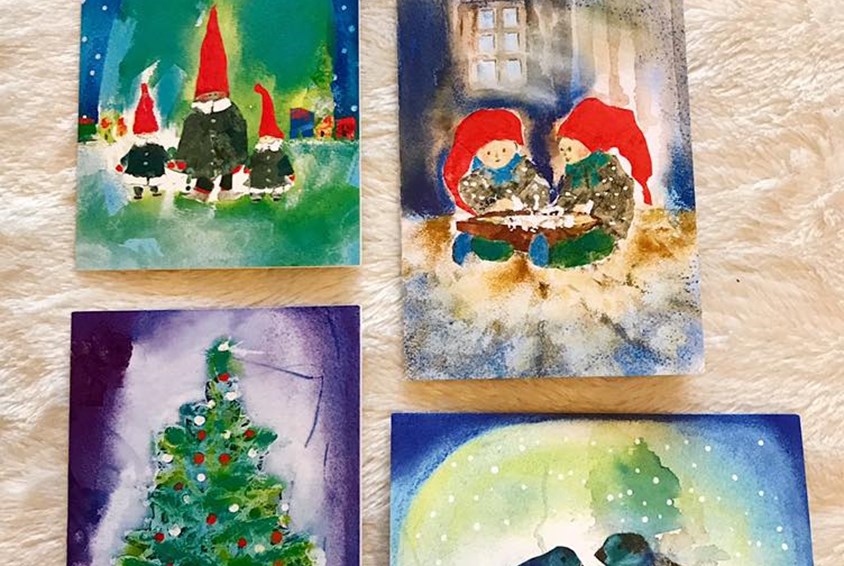 Bilde av fire ulike julekort med motiv av nisser, juletre og to fugler.