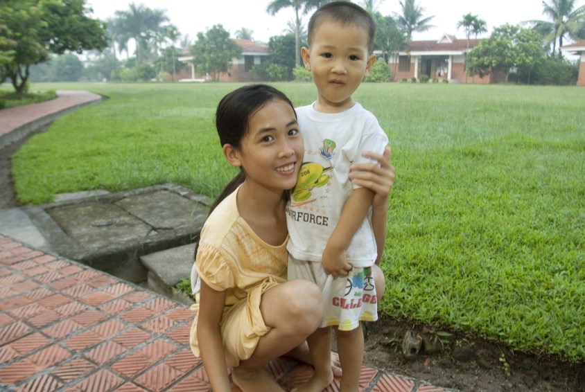 Godt å ha en omsorgsfull storesøster. Vietnam.Foto: Benno Neeleman