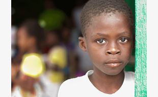 Portrett av alvorlig gutt fra Haiti, med hvit t-skjorte. Foto: SOS-barnebyer