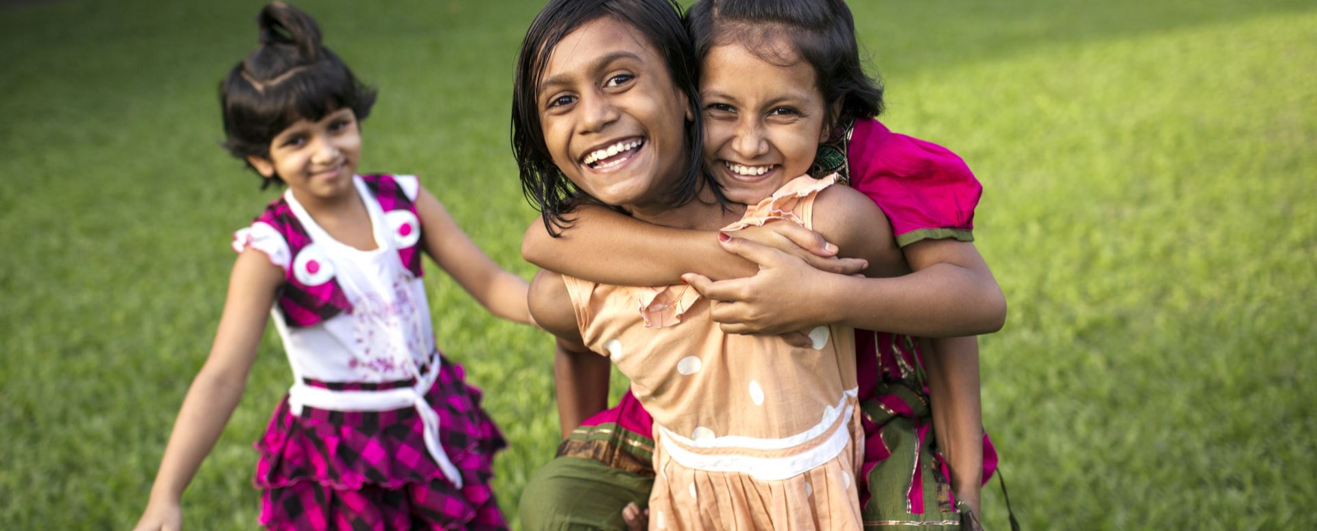 Om ettermiddagen når barna har kommet hjem fra skolen og leksene er unnagjort, leker de ute. Jentene bor i en barneby i Dhaka. Foto: Conor Ashleigh