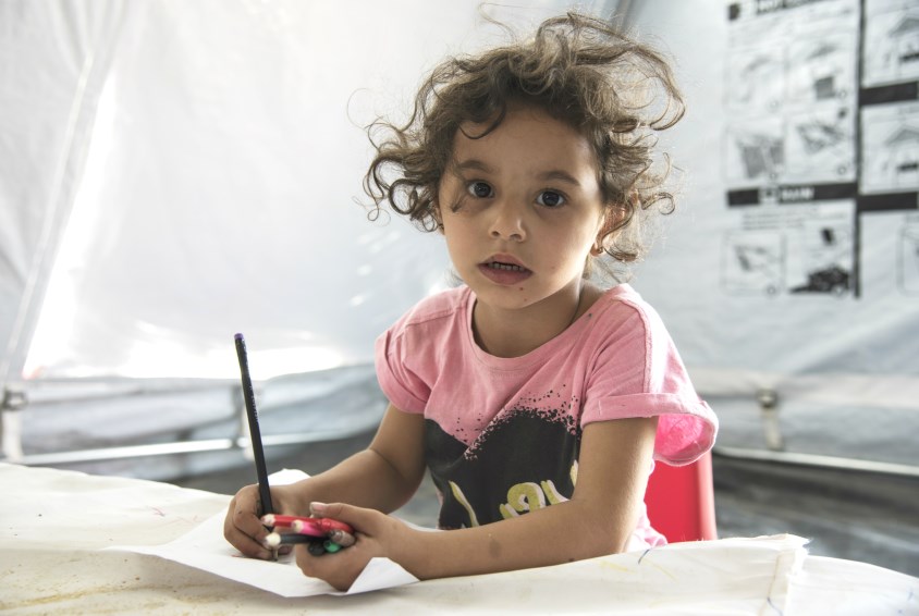 En jente tegner i et barnevennlig område i flyktningleiren i Makedonia. Foto: Katerina Ilievska