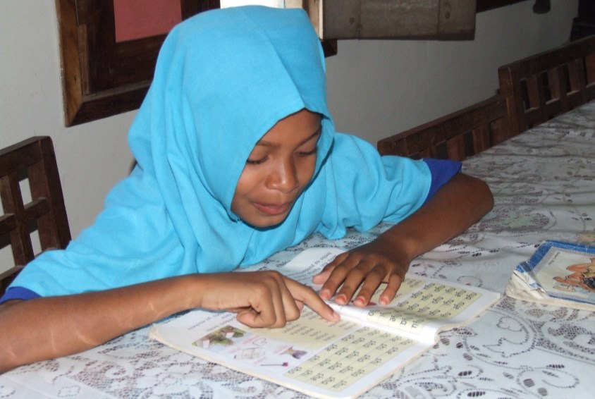 Jente som gjør skolearbeid i Tanzania. Foto: Hilary Atkins