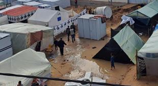Magne telt utenfor SOS-barnebyen i Rafah. Bakken er oversvømt av brunt vann. Foto SOS-barnebyer