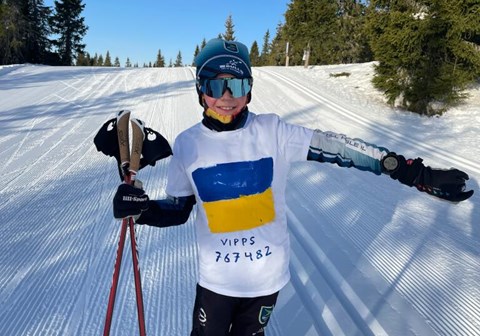 Magnus Semb (10 år) i løypene på Sjusjøen. 
han har hvit t-skjorte utenpå skidressen der han har malt de ukrainske fargene og vippsnr. 767482. Foto: Privat