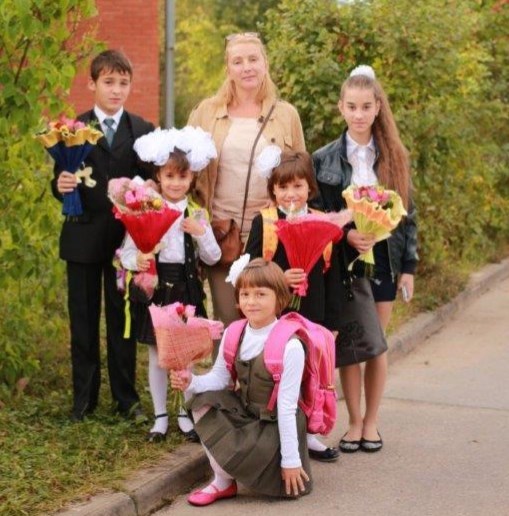 Dette bildet er tatt to måneder før flystyrten. Det er SOS-mor Elenas bursdag og her får hun blomster før hun følger barna på skolen. Foto: SOS-barnebyer