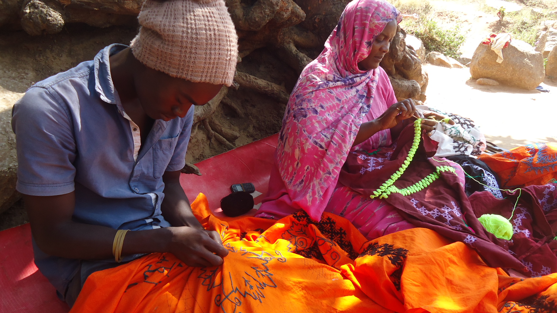 Når Bilali ikke er på skolen eller reparer biler, hjelper han moren med å sy og brodere sengetøy og bordduker. Foto: Catherine Kasimbazi       