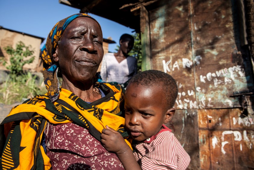 En bestemor, som er med i SOS-barnebyers spare- og lånegruppe, sammen med barnebarnet etter et møte i gruppen i Bugarika. Foto: Bjørn-Owe Holmberg
