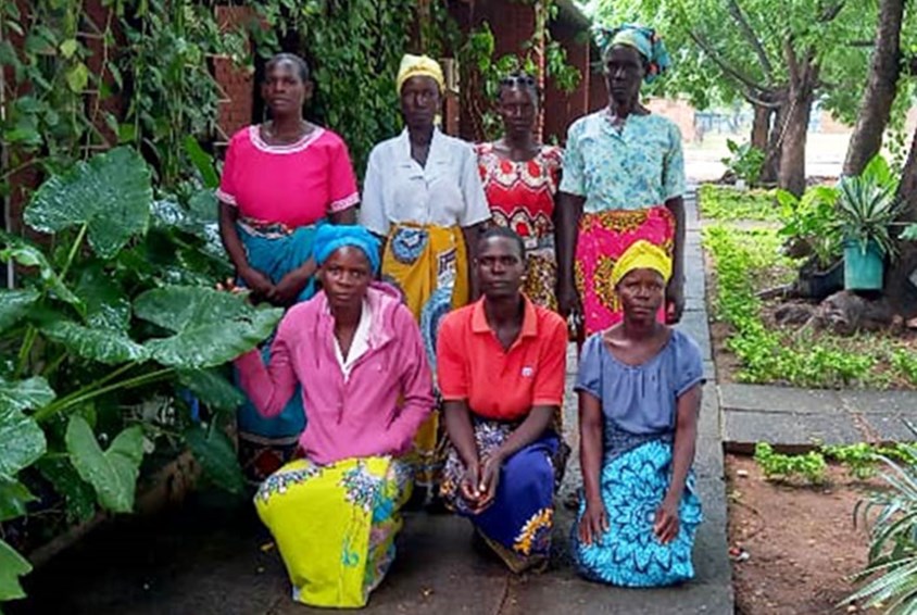 Syv kvinner som er med i foreldregruppen står samlet. De har fargerike klær. Foto: SOS-barnebyer