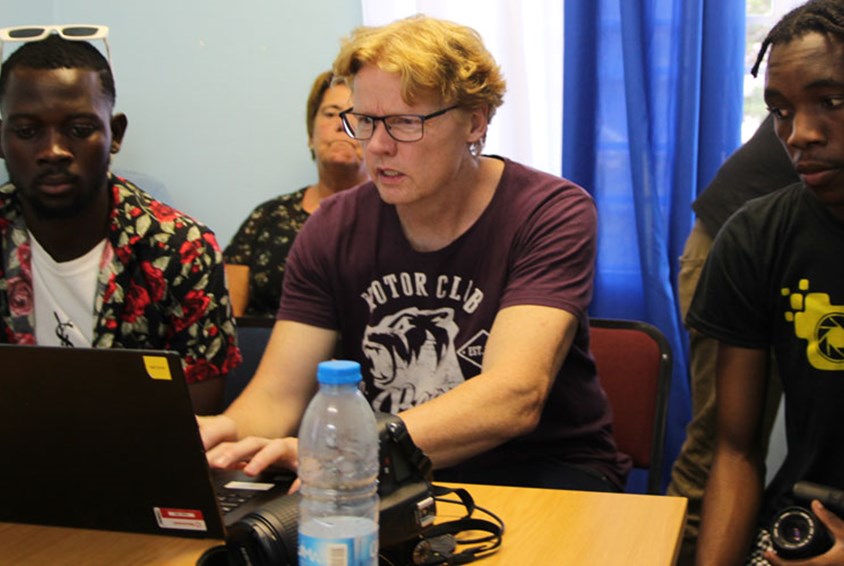 Knut Brobakken sitter foran PCen med noen av kursdeltagerne. Foto: SOS-barnebyer