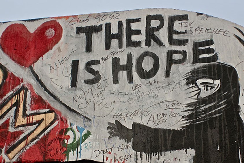 En vegg der det er malt et menneske med langt mørkt hår og et hjerte, med teksten: There is hope. Foto: SOS-barnebyer