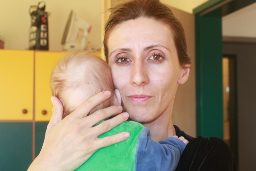 SOS-mor med en av spedbarna hun har ansvaret for i babysenteret til SOS-barnebyer i Pristina. Foto: SOS-arkiv