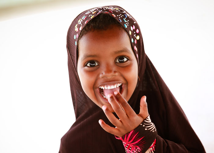 Jente med brun hijab, smiler strålende. Foto: On Screen Productions Kevin Ouma