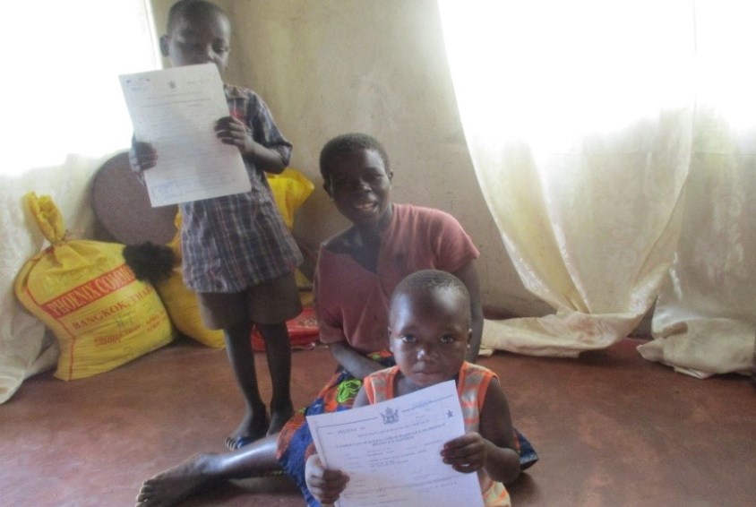 En gald familie etter at barna har fått fødselsattest som gir dem en identitet. Foto: SOS Zimbabwe