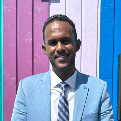Dakane Abdidakir, leder for SOS-barnebyer i Somalia. Han har på seg hvit skjorte, lys blå dressjakke, stripet blått og hvitt slips. Foto: SOS-barnebyer