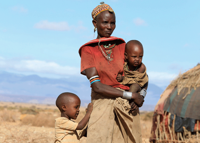 Nkatvie og to av barna hennes. Hun bærer det minste barnet på armen og en liten gutt har et godt tak i skjørtet hennes. Foto: Noor Kamis