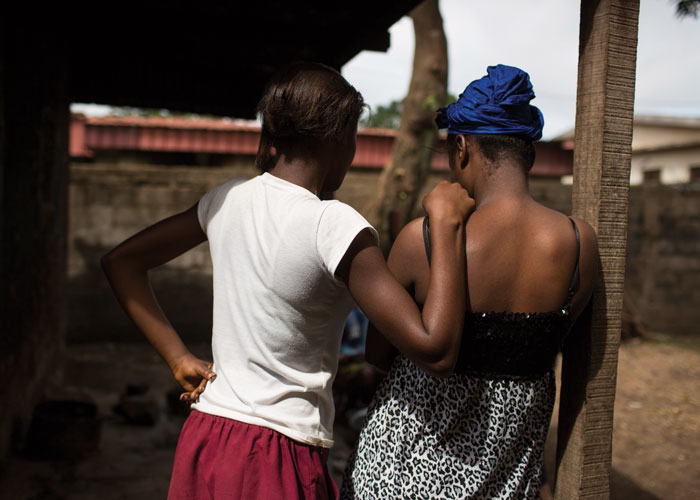 To unge jenter fra et Afrikansk land står med ryggen til, den ene holder den andre på skulderen. Illustrasjonsfoto: Conor Ashleigh
