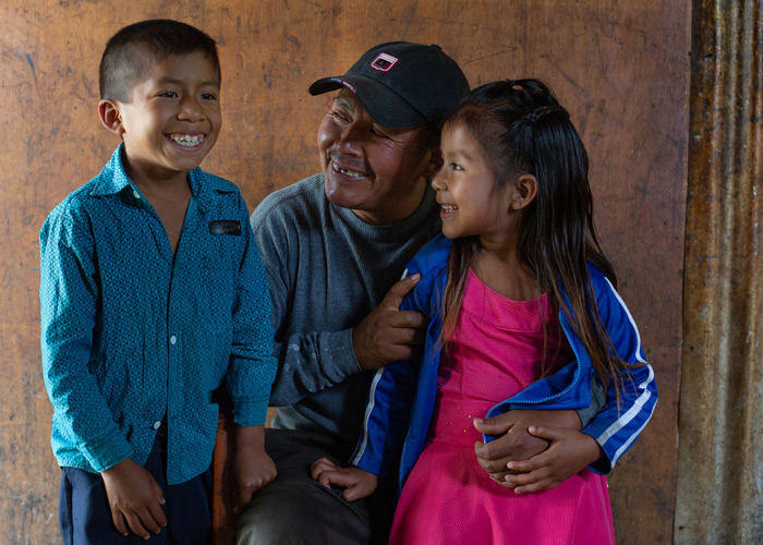 Pappa Carlos fra Mexico med sin sønn og datter. De smiler. Foto: Erika Tanzer