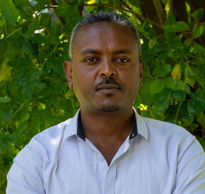 Zelalem Ashenafi er prosjektkoordinator for vårt forebyggende arbeid i Etiopia. Han har grått kort hår, bart og har på seg en hvit skjorte. Foto: SOS-barnebyer