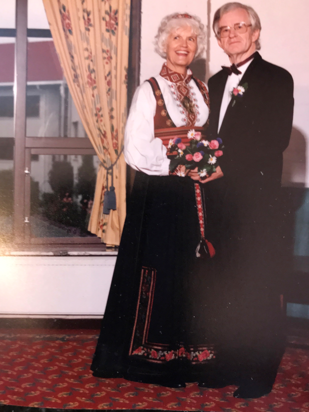 Bryllupsbilde av Berit Sørhus Tveter og hennes mann. Hun har på seg bunad og holder en rosebukett i hånda, og mannen hennes i dress. Foto: Privat. 